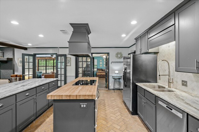 1492 Sleepy Hollow Ln, Canton, TX 75103 - kitchen with backsplash, a sink, butcher block counters, brick floor, and appliances with stainless steel finishes