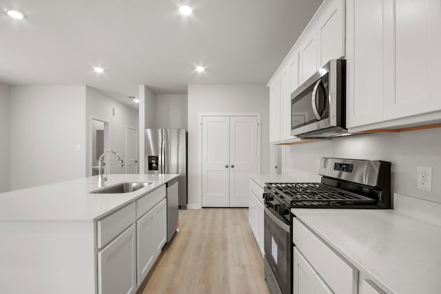 21429 Mary Myrtle St, Spring, TX 77379 - kitchen with stainless steel appliances, light wood finished floors, light countertops, a kitchen island with sink, and recessed lighting