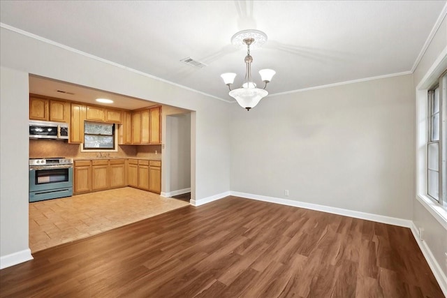 kitchen with dark wood-style flooring, ornamental molding, stainless steel appliances, and an inviting chandelier