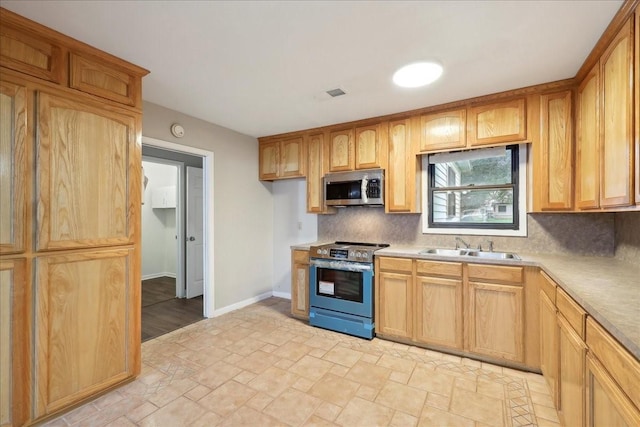 kitchen featuring stainless steel appliances, backsplash, stone finish floor, light countertops, and visible vents