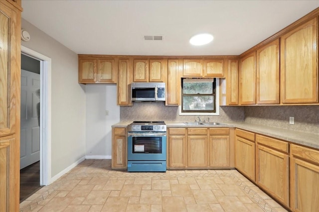 kitchen featuring light countertops, visible vents, a sink, stone finish flooring, and appliances with stainless steel finishes