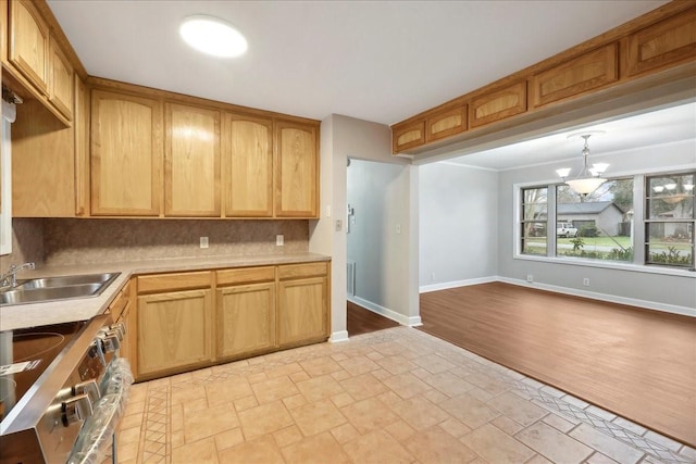 kitchen featuring stainless steel electric stove, a sink, stone tile floors, backsplash, and light countertops