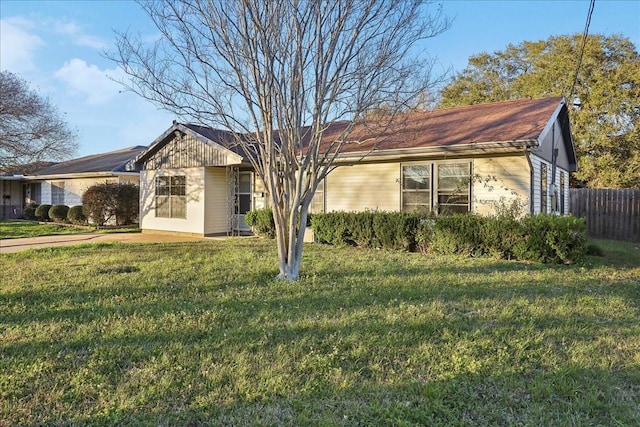 single story home featuring a front yard and fence