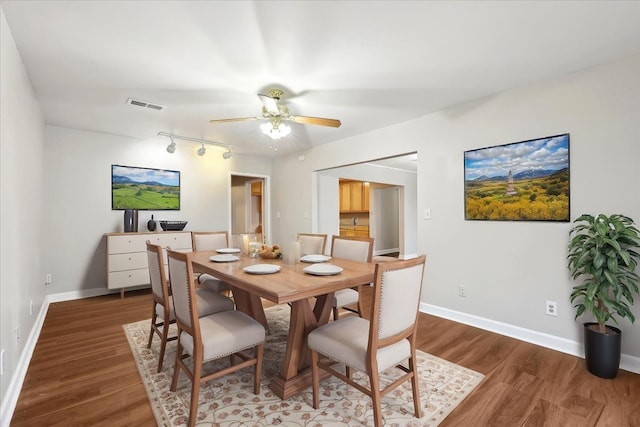 dining space featuring wood finished floors, visible vents, a ceiling fan, and baseboards