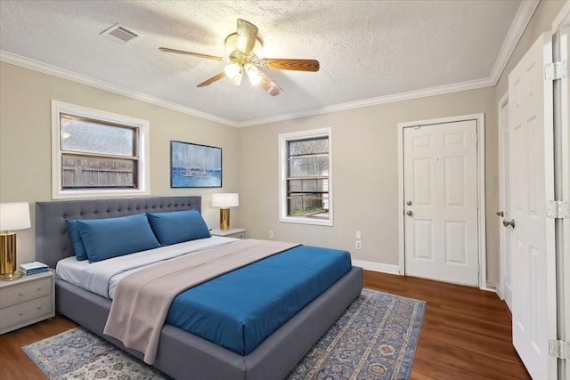 bedroom with wood finished floors, visible vents, and a textured ceiling