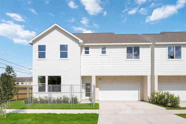 multi unit property featuring fence, a front lawn, concrete driveway, roof with shingles, and a garage