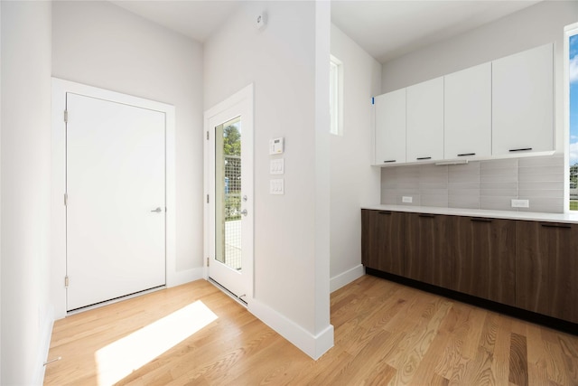 foyer entrance with light wood-type flooring and baseboards