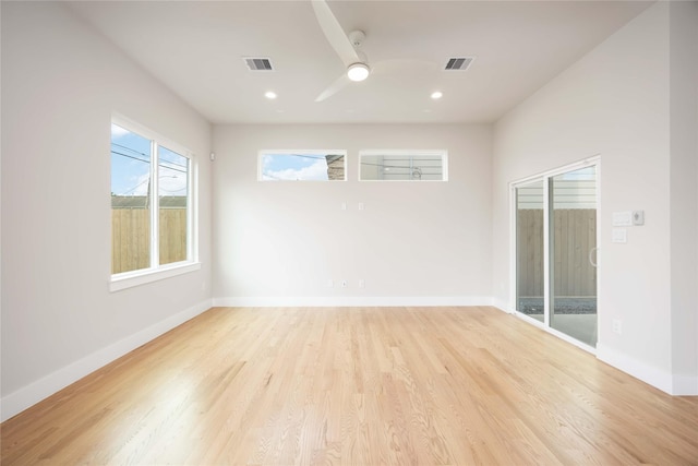 spare room with light wood-style floors, visible vents, and baseboards