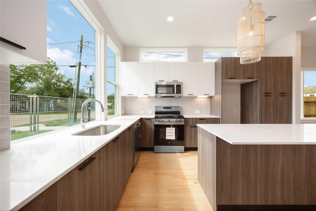 kitchen with modern cabinets, appliances with stainless steel finishes, and a sink