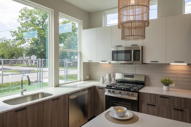 1810 Yates St, Houston, TX 77020 - kitchen with appliances with stainless steel finishes, a sink, modern cabinets, light countertops, and decorative backsplash
