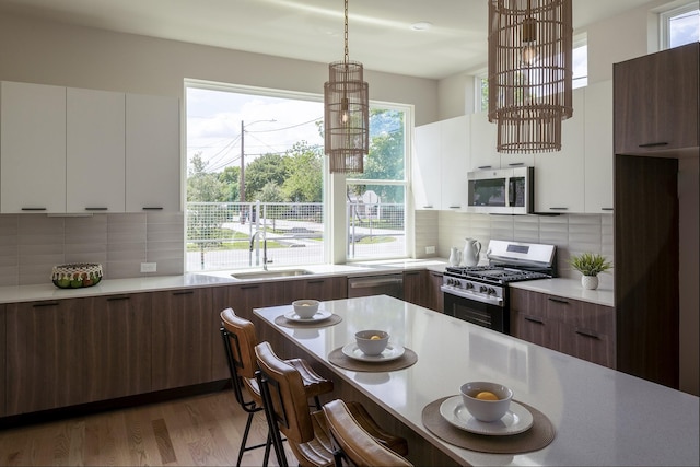 1810 Yates St, Houston, TX 77020 - kitchen with stainless steel appliances, a sink, modern cabinets, white cabinets, and a kitchen breakfast bar