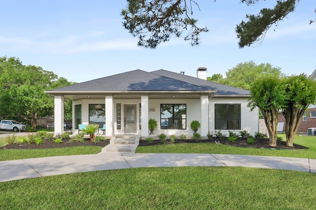 9834 E Shore Dr, Willis, TX 77318 - view of front of house featuring a porch, a shingled roof, a front yard, central AC unit, and a chimney