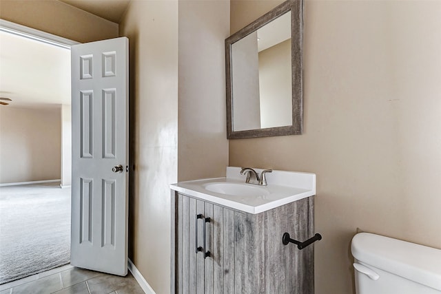 bathroom with vanity, toilet, tile patterned flooring, and baseboards