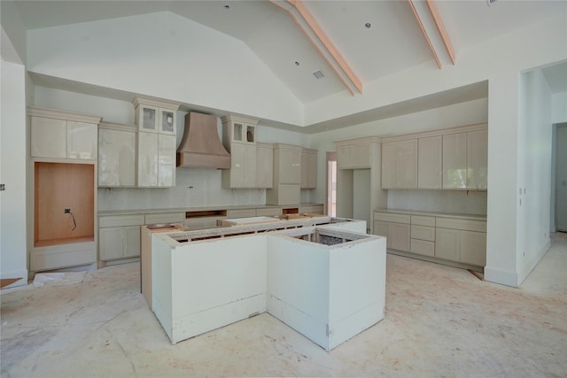 kitchen featuring a center island, custom range hood, high vaulted ceiling, cream cabinets, and decorative backsplash