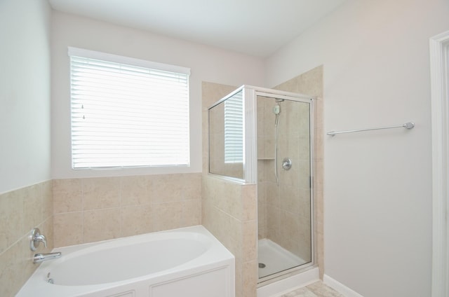 full bathroom with a bath and a stall shower