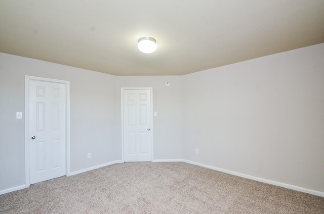 spare room with baseboards and carpet floors