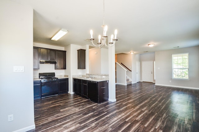 kitchen featuring under cabinet range hood, dark wood-style floors, and range with gas stovetop