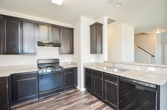 kitchen with under cabinet range hood, a sink, gas range oven, a peninsula, and black dishwasher