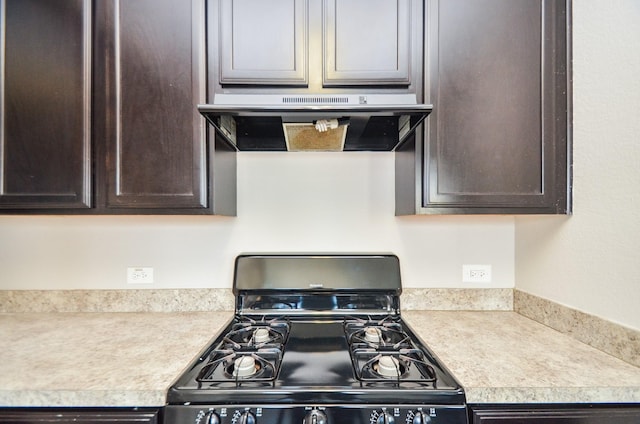 kitchen featuring dark brown cabinets, light countertops, black gas range, and extractor fan
