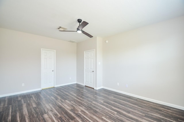 empty room featuring ceiling fan, baseboards, dark wood-style flooring, and visible vents