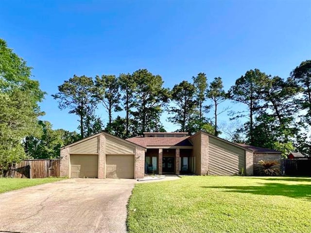 210 Glenbrook St, Vidor, TX 77662 - mid-century modern home featuring an attached garage, driveway, a front lawn, and fence