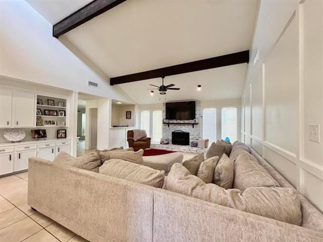 210 Glenbrook St, Vidor, TX 77662 - living room featuring light tile patterned floors, ceiling fan, beamed ceiling, a fireplace, and visible vents