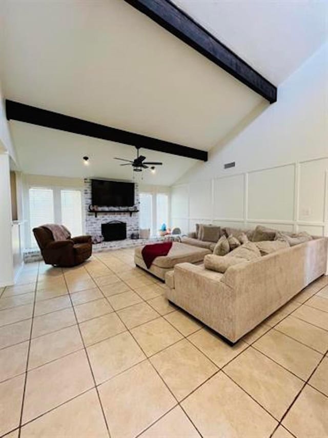 210 Glenbrook St, Vidor, TX 77662 - living area featuring beamed ceiling, a ceiling fan, a decorative wall, a fireplace, and light tile patterned floors