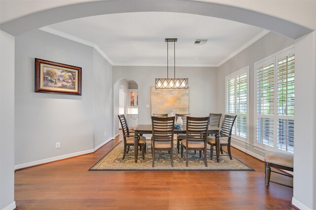 314 Del Monte Dr, Friendswood, TX 77546 - dining area with arched walkways, baseboards, visible vents, wood finished floors, and crown molding