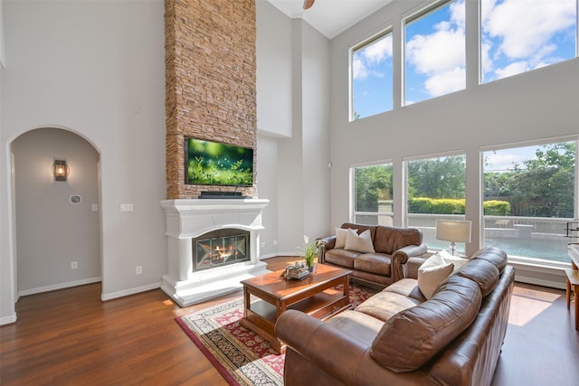 314 Del Monte Dr, Friendswood, TX 77546 - living area with wood finished floors, baseboards, arched walkways, a fireplace, and a high ceiling