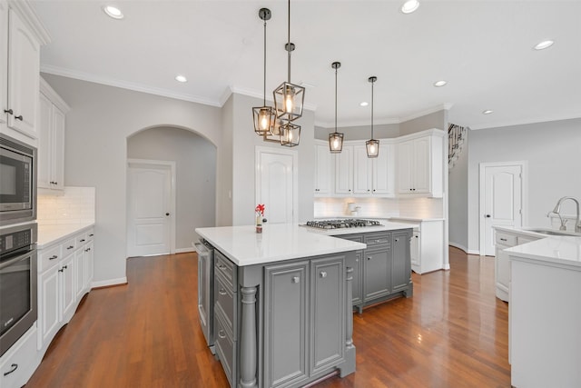 314 Del Monte Dr, Friendswood, TX 77546 - kitchen featuring a center island, arched walkways, a sink, gray cabinetry, and appliances with stainless steel finishes