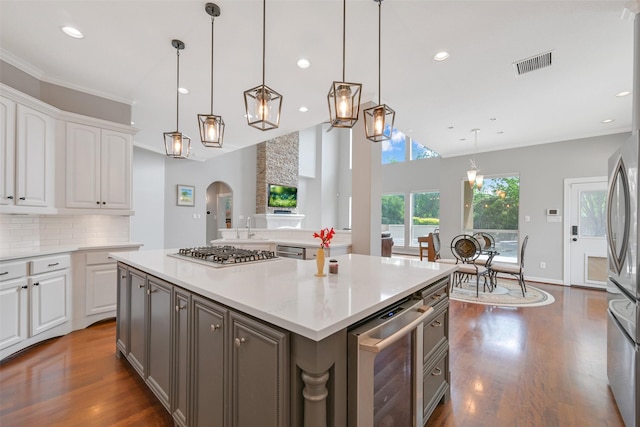 314 Del Monte Dr, Friendswood, TX 77546 - kitchen with white cabinets, stainless steel appliances, dark wood finished floors, visible vents, and beverage cooler