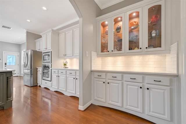 314 Del Monte Dr, Friendswood, TX 77546 - kitchen with arched walkways, visible vents, appliances with stainless steel finishes, and ornamental molding