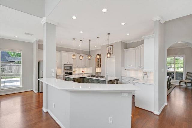 314 Del Monte Dr, Friendswood, TX 77546 - kitchen with a healthy amount of sunlight, arched walkways, appliances with stainless steel finishes, and a spacious island