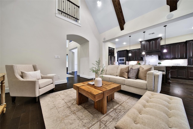 182 River Wilde Dr, Montgomery, TX 77316 - living area with arched walkways, dark wood-style floors, high vaulted ceiling, beamed ceiling, and baseboards