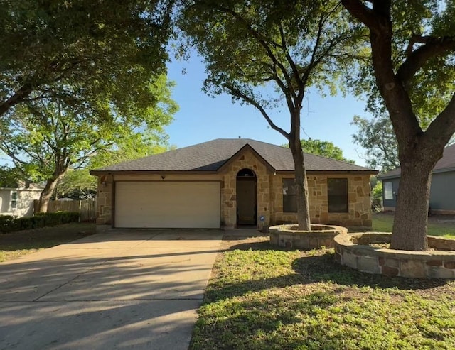 ranch-style home featuring an attached garage, driveway, and stone siding
