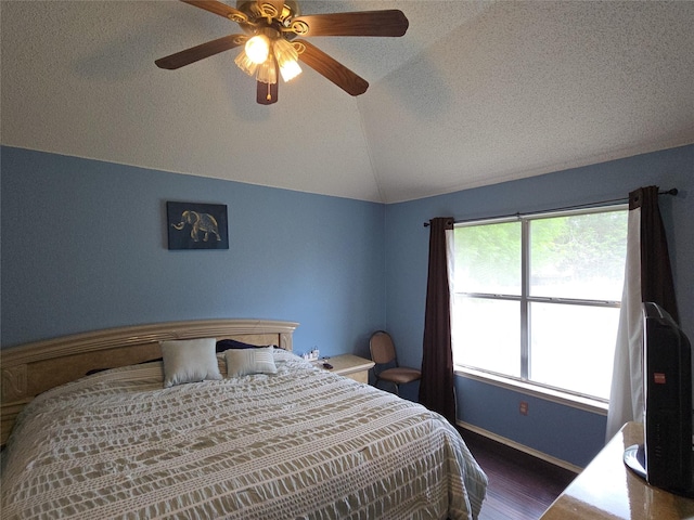bedroom with ceiling fan, a textured ceiling, baseboards, wood finished floors, and lofted ceiling