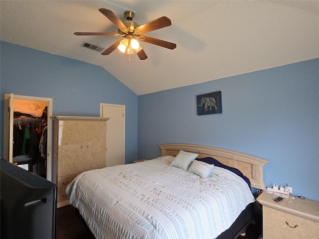 bedroom featuring visible vents, a closet, a spacious closet, a ceiling fan, and vaulted ceiling