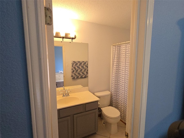 bathroom with vanity, toilet, a textured ceiling, tile patterned floors, and a shower with curtain
