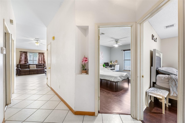 2403 Lendall Ln, Austin, TX 78744 - corridor with light tile patterned flooring, baseboards, visible vents, and a textured ceiling