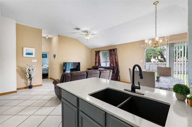 2403 Lendall Ln, Austin, TX 78744 - kitchen featuring visible vents, lofted ceiling, light stone counters, a sink, and ceiling fan with notable chandelier