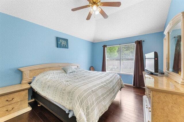 2403 Lendall Ln, Austin, TX 78744 - bedroom featuring a ceiling fan, vaulted ceiling, dark wood finished floors, and a textured ceiling
