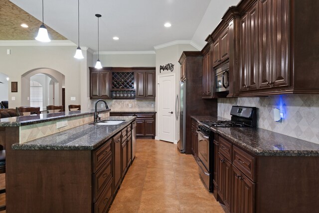 17111 Paluxy Ct, Splendora, TX 77372 - kitchen with stainless steel appliances, a sink, arched walkways, crown molding, and dark brown cabinets