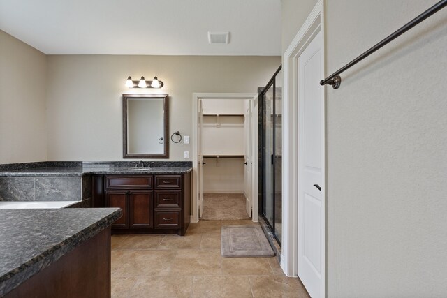17111 Paluxy Ct, Splendora, TX 77372 - bathroom featuring vanity, a stall shower, a walk in closet, and stone finish floors