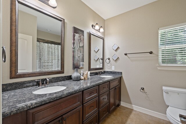 17111 Paluxy Ct, Splendora, TX 77372 - bathroom featuring toilet, double vanity, baseboards, and tile patterned floors