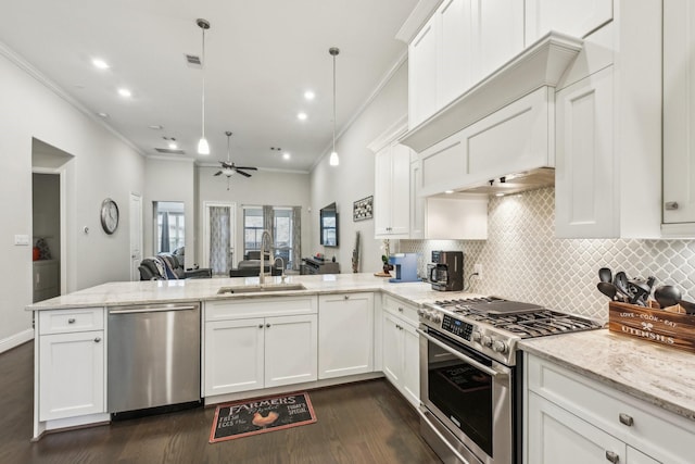 kitchen featuring crown molding, a peninsula, appliances with stainless steel finishes, and a sink