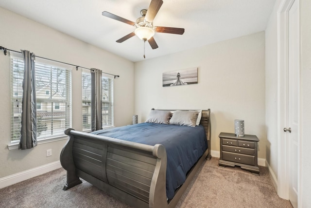 carpeted bedroom with a ceiling fan, baseboards, and multiple windows