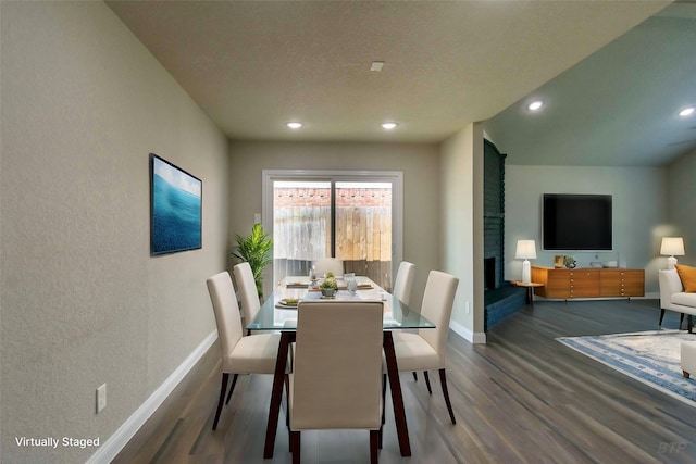 dining room with baseboards, a brick fireplace, wood finished floors, and recessed lighting