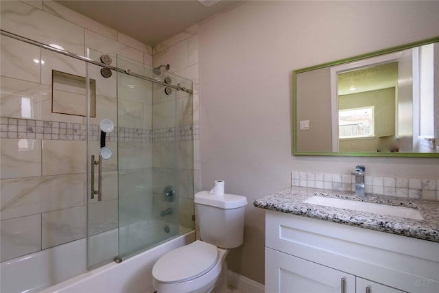 full bath featuring toilet, vanity, and combined bath / shower with glass door