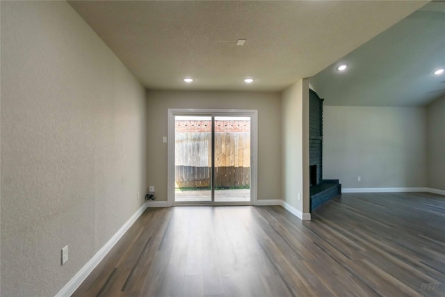 empty room featuring dark wood-type flooring, baseboards, and recessed lighting