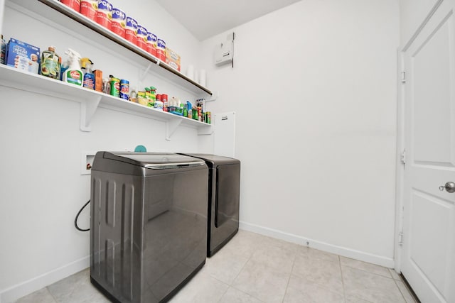 clothes washing area with baseboards, laundry area, and independent washer and dryer